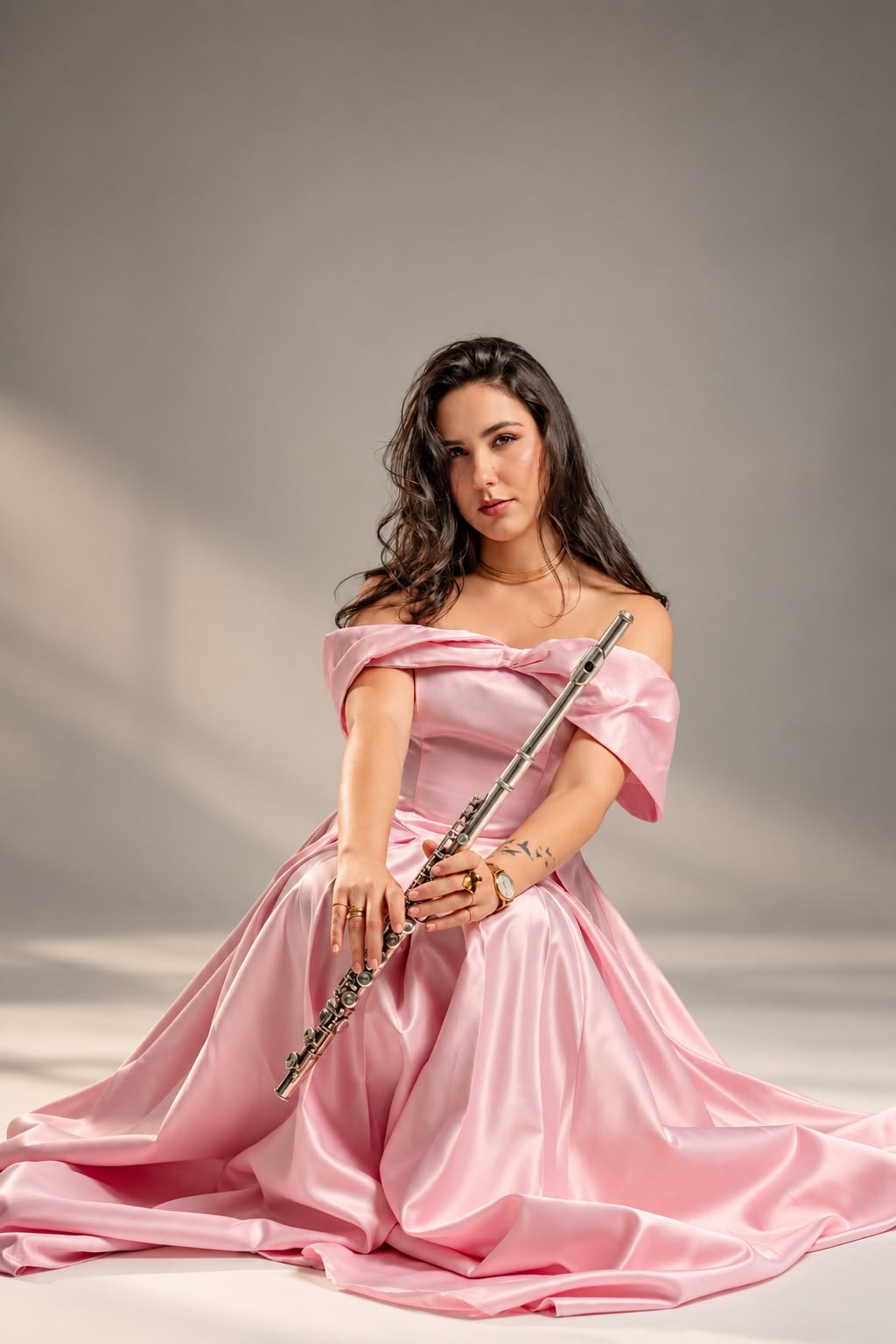 Legna Otero seated in a pink gown with her flute